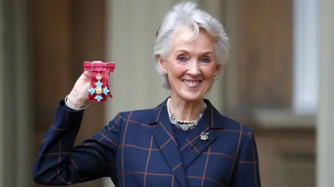 PA Media File photo dated 22/03/01 of Queen Elizabeth II (right) meeting Joanna Trollope at Bloomsbury Publishing in London.