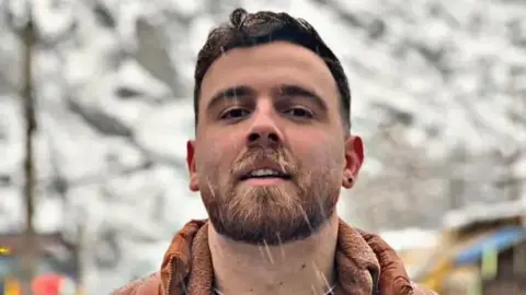 Erfan Soltani, 26, looks at the camera as snow falls; rights groups say he faces execution after a rushed trial.