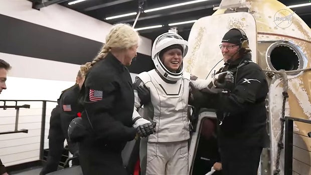 Crew 11 commander Zena Cardman smiles as she is helped from the Crew Dragon capsule after splashdown.