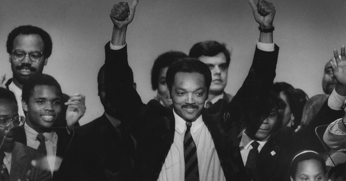 Rev. Jesse Jackson raises his arms to greet supporters.