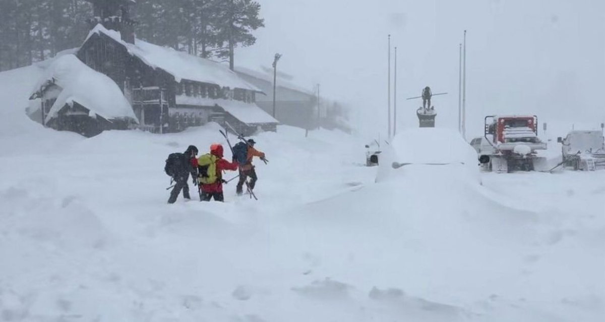 Rescue teams and skiers move through deep snow near Castle Peak during search-and-rescue operations after the avalanche.