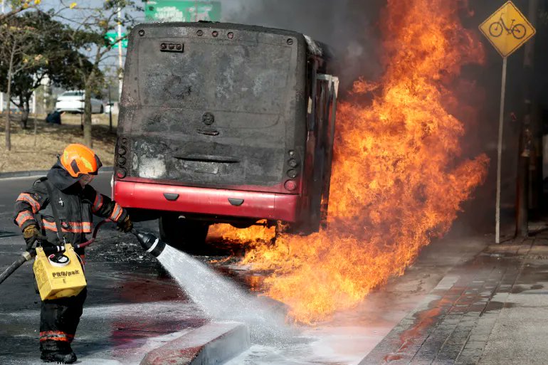 Firefighter works to extinguish a burning bus during unrest in Jalisco after the raid on CJNG leader 'El Mencho'