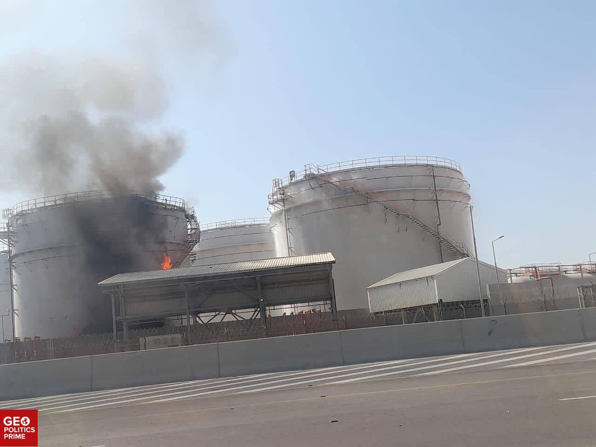 Thick black smoke rises from burning fuel tanks at a port facility, reportedly in Salalah, Oman
