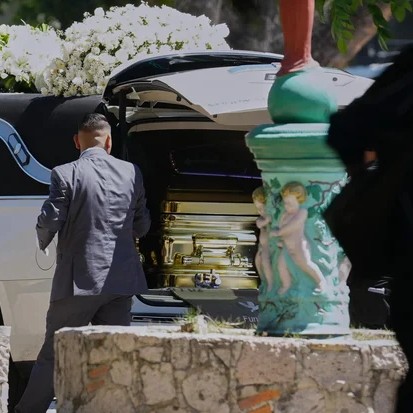 A funeral worker opens the door of a car carrying the remains of who authorities identified as the late Jalisco New Generation Cartel leader Nemesio Oseguera, alias "El Mencho," at Recinto de Paz cemetery in Guadalajara, Mexico, Monday, March 2, 2026. - Refugio Ruiz / AP
