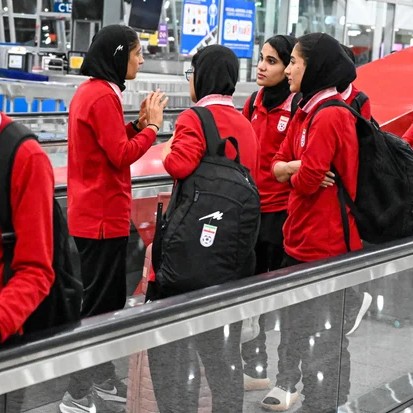 Members of Iran's women's soccer team talk as they arrive at the Kuala Lumpur International Airport after taking part in the AFC Women's Asian Cup Australia 2026 tournament in Australia, in Sepang on March 11, 2026. - Mohd RASFAN / AFP