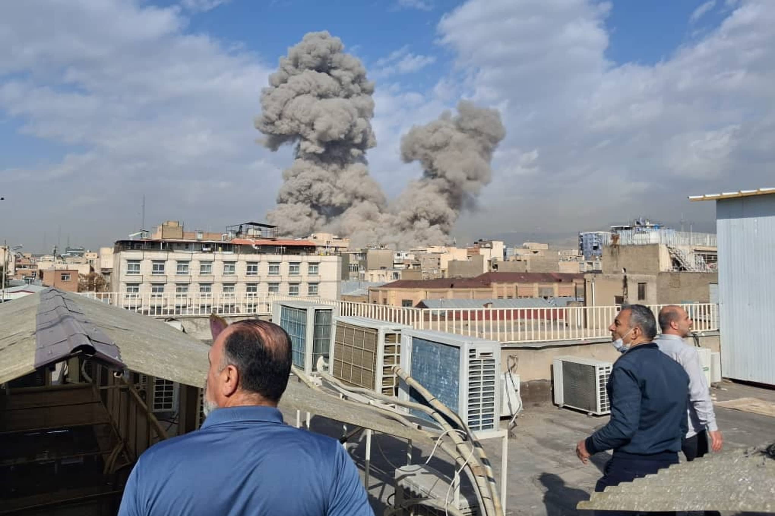 Large smoke plume rises over a city skyline after explosions amid the U.S.-Iran conflict.