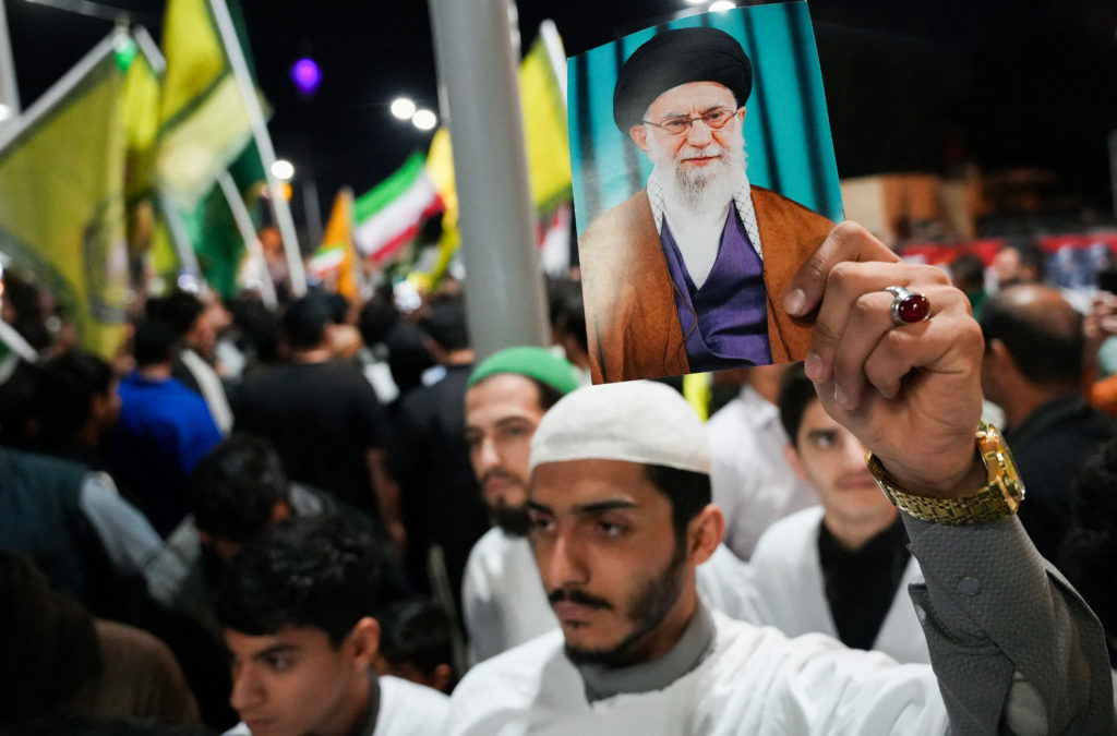 Supporters in Basra hold a portrait of Ayatollah Ali Khamenei during a pro-Iran rally amid regional tensions