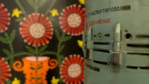 Artwork displayed beside artillery and missile casings inside a Ukrainian drone command center