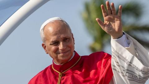 Pope Leo XIV waves during a welcome ceremony upon his arrival at 4 de Fevereiro International Airport in Luanda, Angola