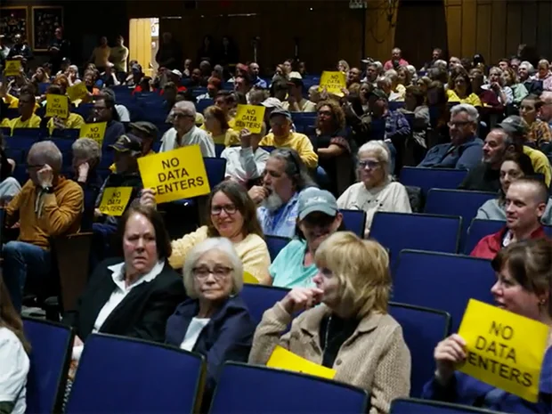 Residents hold 'No data centers' signs at a March 10 community meeting in Archbald, Pennsylvania