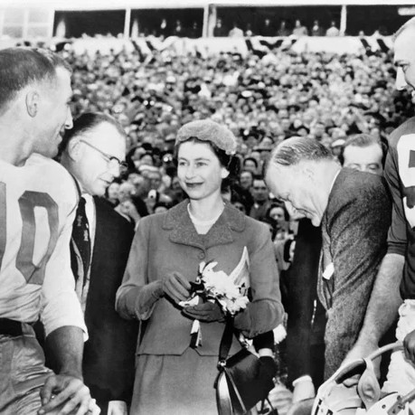 Queen Elizabeth II meets American football players in College Park, Maryland, during a visit on Oct. 21, 1957. - International News Photos/AFP via Getty Images