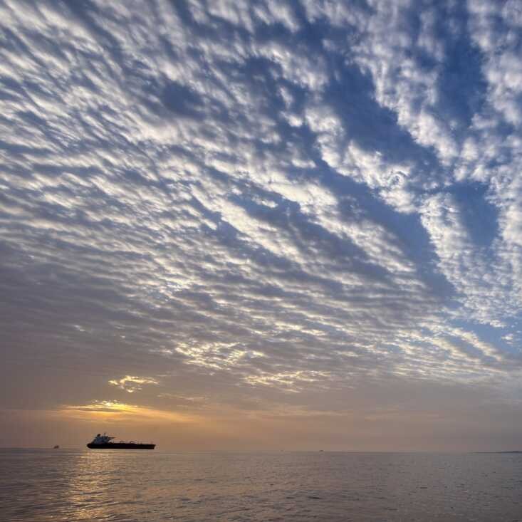 The sun rises behind a tanker anchored in the Strait of Hormuz off the coast of Qeshm Island, Iran, Saturday, April 18, 2026. - Asghar Besharati/AP